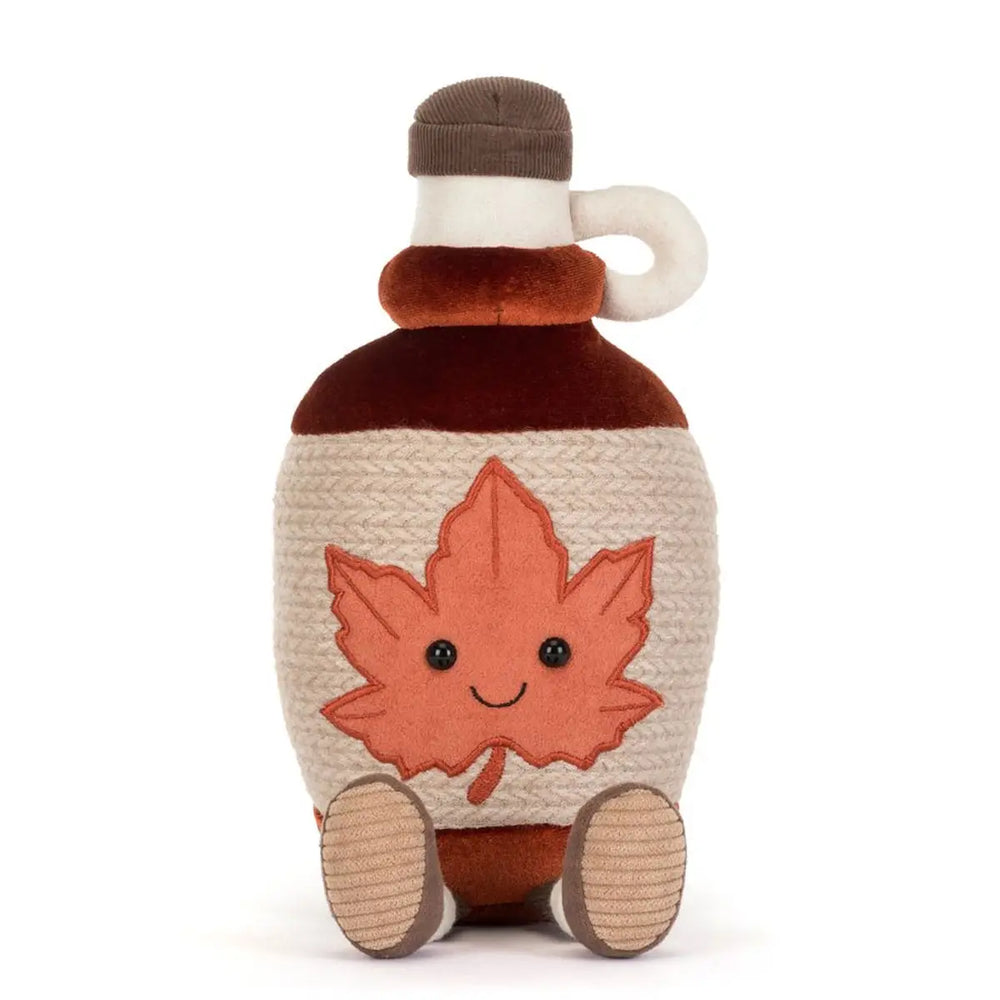 Toy maple syrup bottle with a leaf design on a white background