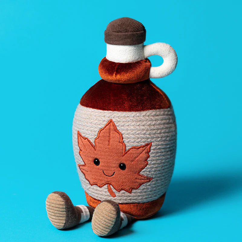Toy maple syrup bottle with a leaf design on a blue background