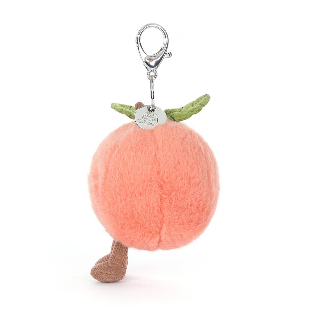 Plush peach keychain with legs and a stem on a white background