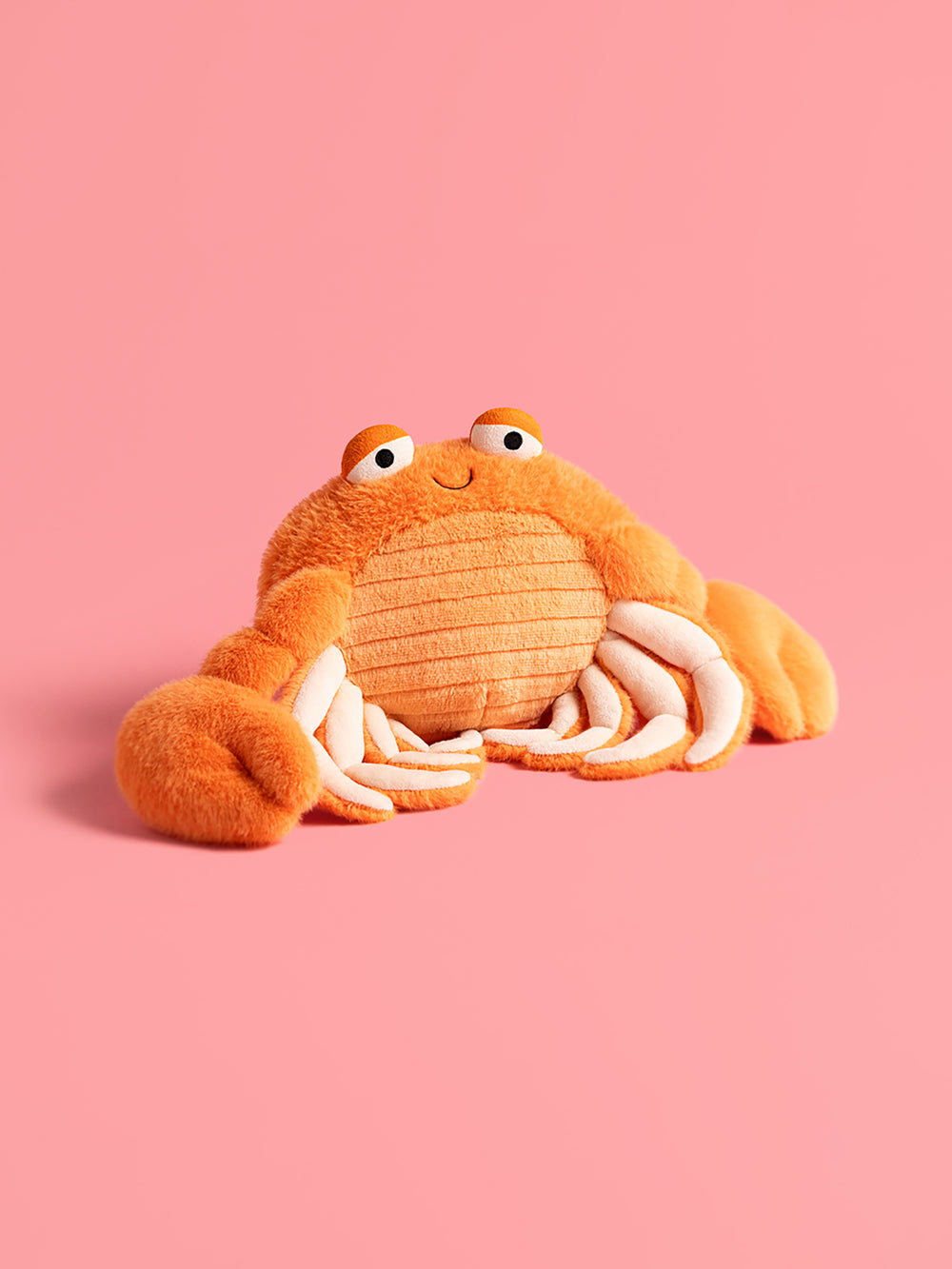 Plush crab toy on a pink background