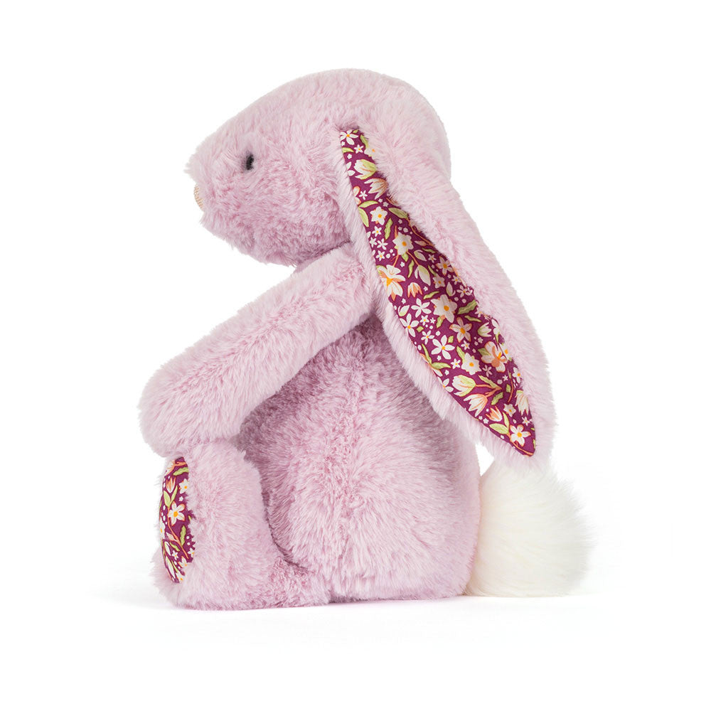 Pink plush bunny with floral ear on a white background