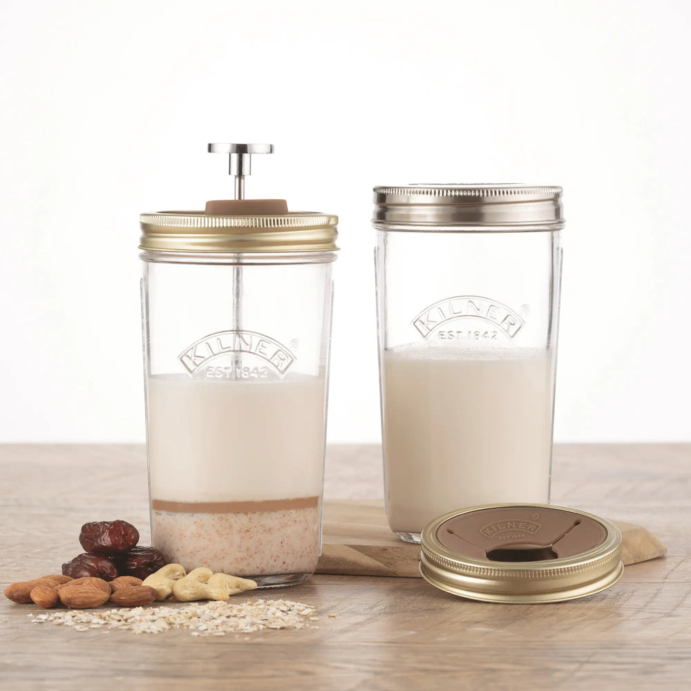 Two glass jars with metal lids on a wooden surface with ingredients.