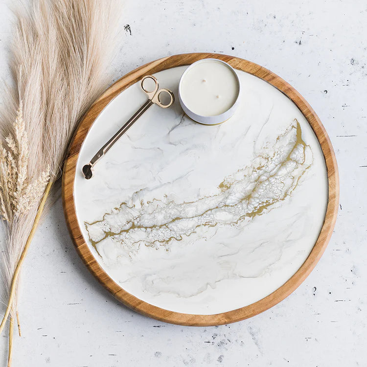A round Acacia hardwood Lazy Susan with a gold quartz-like white center and a darker wood border, designed to display snacks.