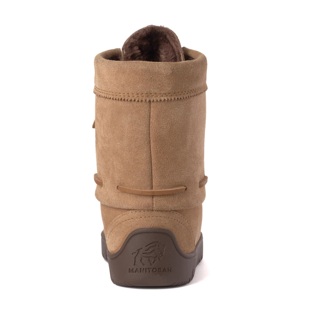 Tan suede boot with a flat brown sole and faux fur lining, featuring lace-up detailing on the front. 