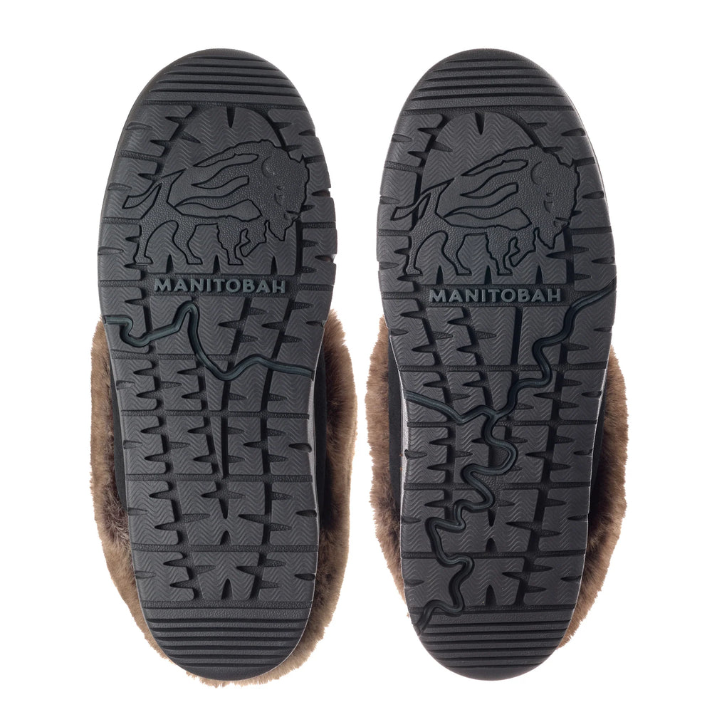 Close-up view of two fur-lined boot soles with patterns and "Manitobah" logo