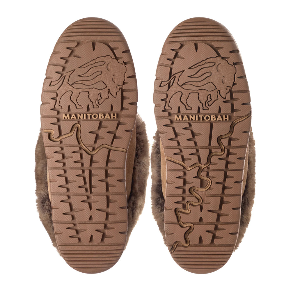 Close-up view of two fur-lined boot soles with patterns and "Manitobah" logo