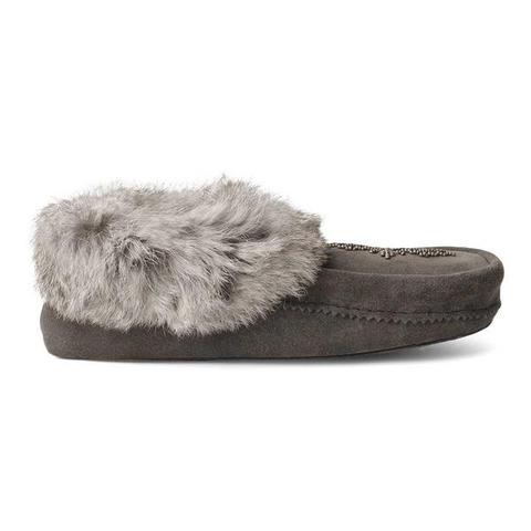 A charcoal moccasin shoe with a soft, fluffy fur trim around the opening, and intricate stitching along the side.