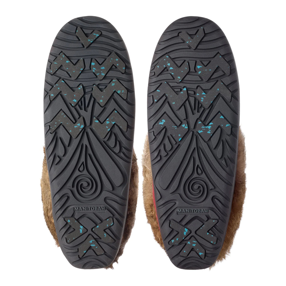 Soles of two fur-trimmed boots with intricate black patterns and turquoise speckles. 