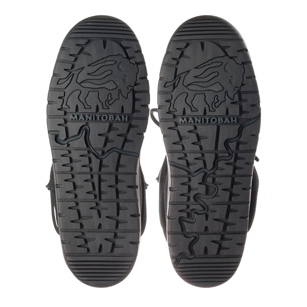 Soles of two black boots featuring intricate tread patterns. A buffalo design and the word "MANITOBAH".