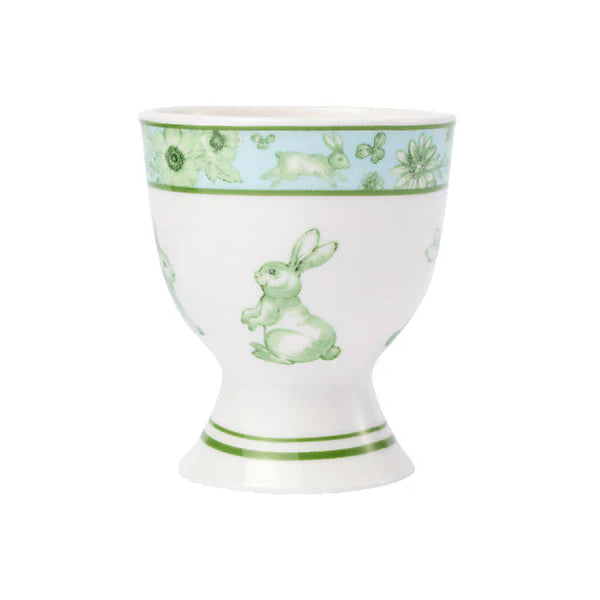 White egg cup with green rabbit design on a white background