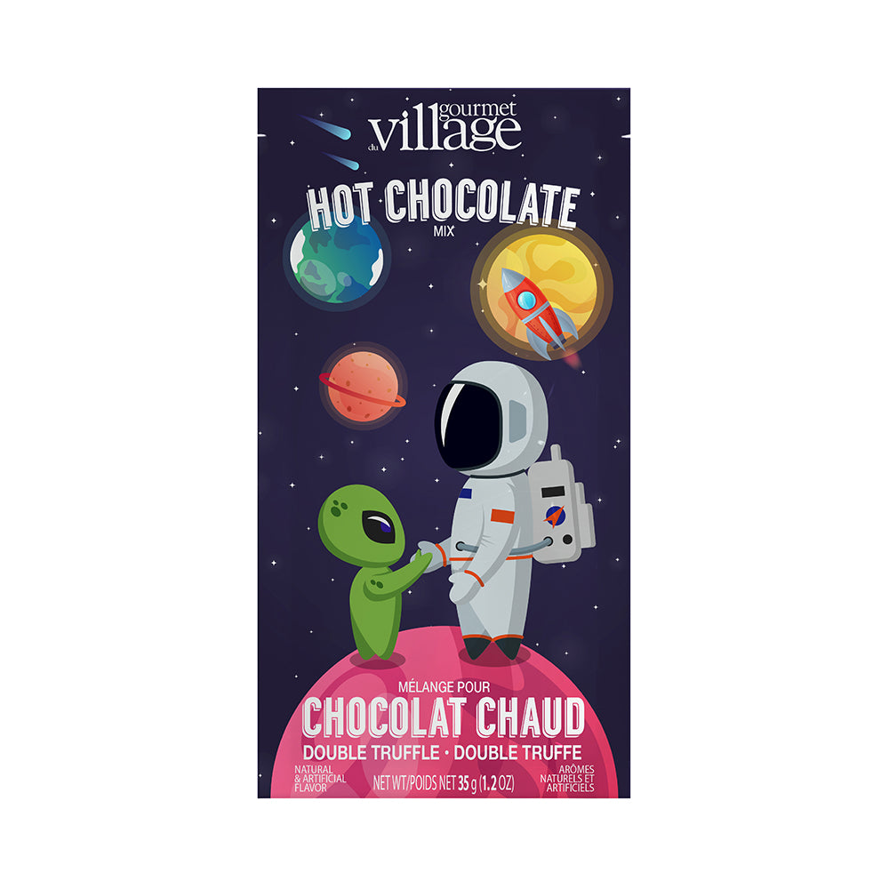 An astronaut and green alien shake hands on a pink planet amid colorful planets and stars. Text reads "Gourmet Village Hot Chocolate Mix, Double Truffle."