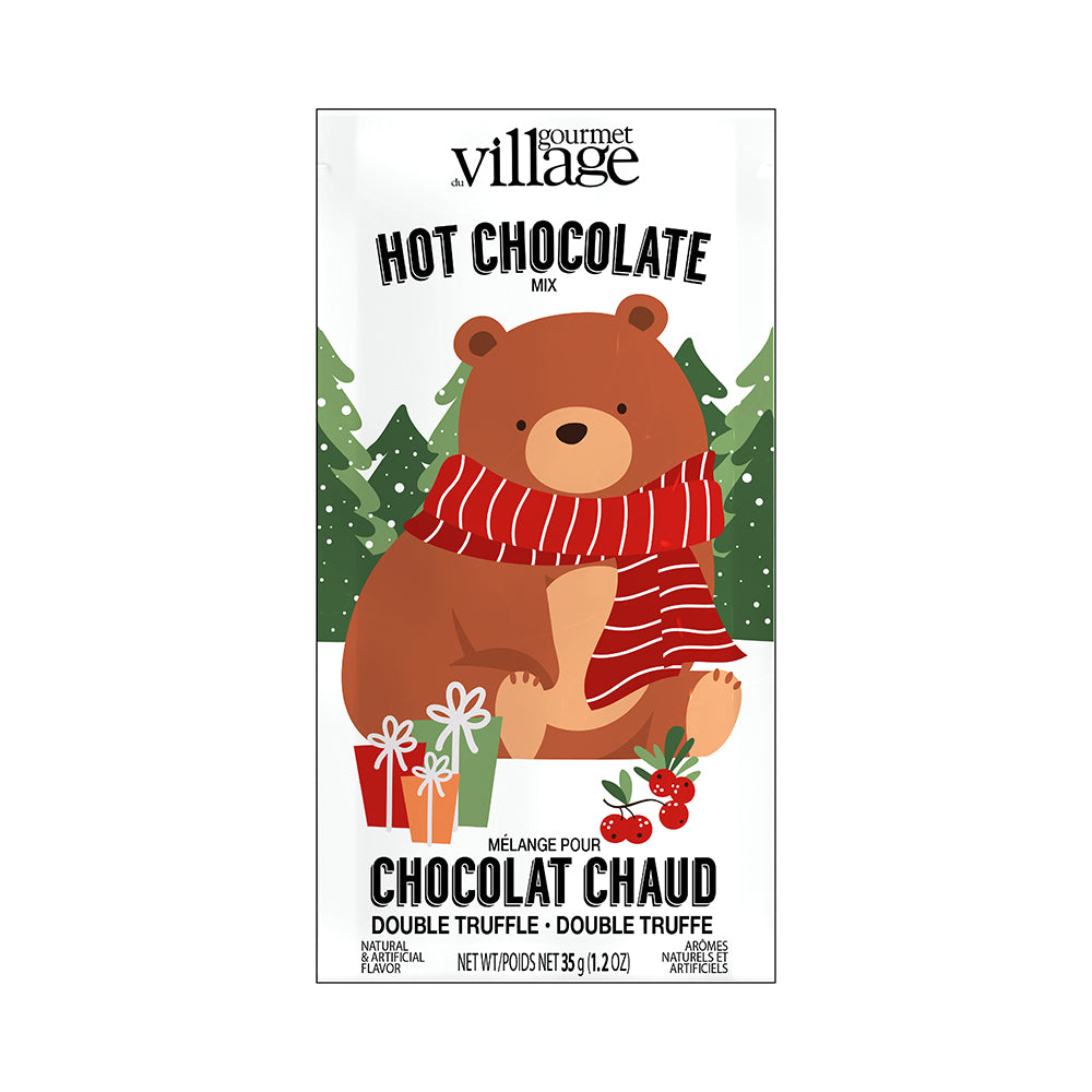 Cute brown bear wearing a red scarf holds gifts with a snowy pine tree background. Text reads "Hot Chocolate Mix" and "Chocolat Chaud." 