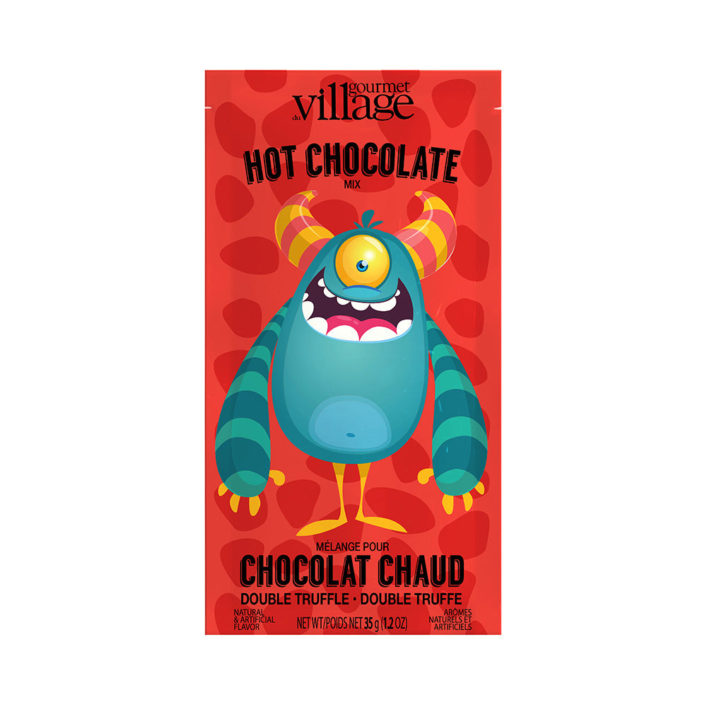 Colorful packaging for Gourmet Village hot chocolate mix features a playful, one-eyed monster with striped horns on a red background with chocolate truffle text.