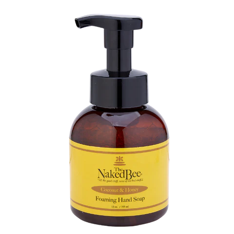Amber glass bottle with pump and yellow label featuring 'The Naked Bee' on a white background