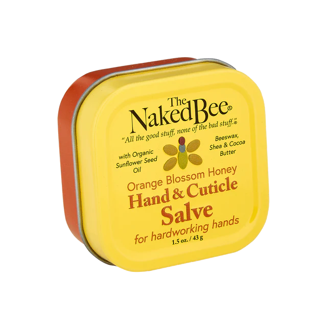 A yellow tin container of The Naked Bee Orange Blossom Honey Hand & Cuticle Salve with product details visible on the label.