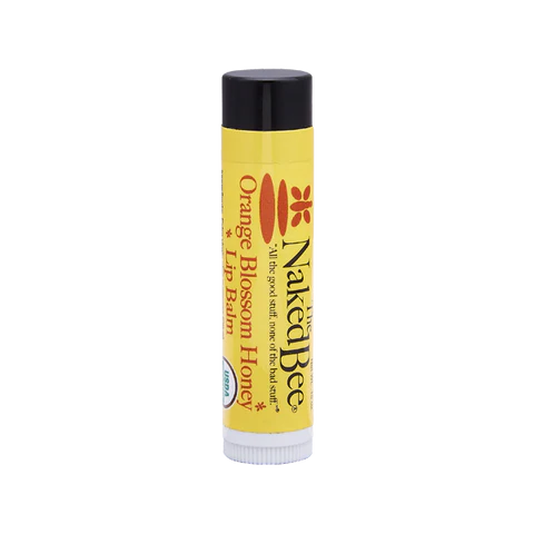 A stick of 'The Naked Bee Orange Blossom Honey Organic Lip Balm' with black cap and yellow body, labeled with the brand name and product details.