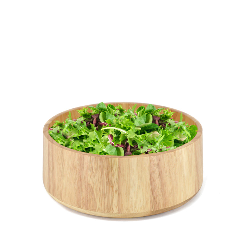 Wooden bowl on a white background filled with greens