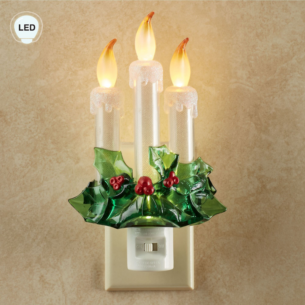 Decorative night light with candle design and holly leaves on a beige background