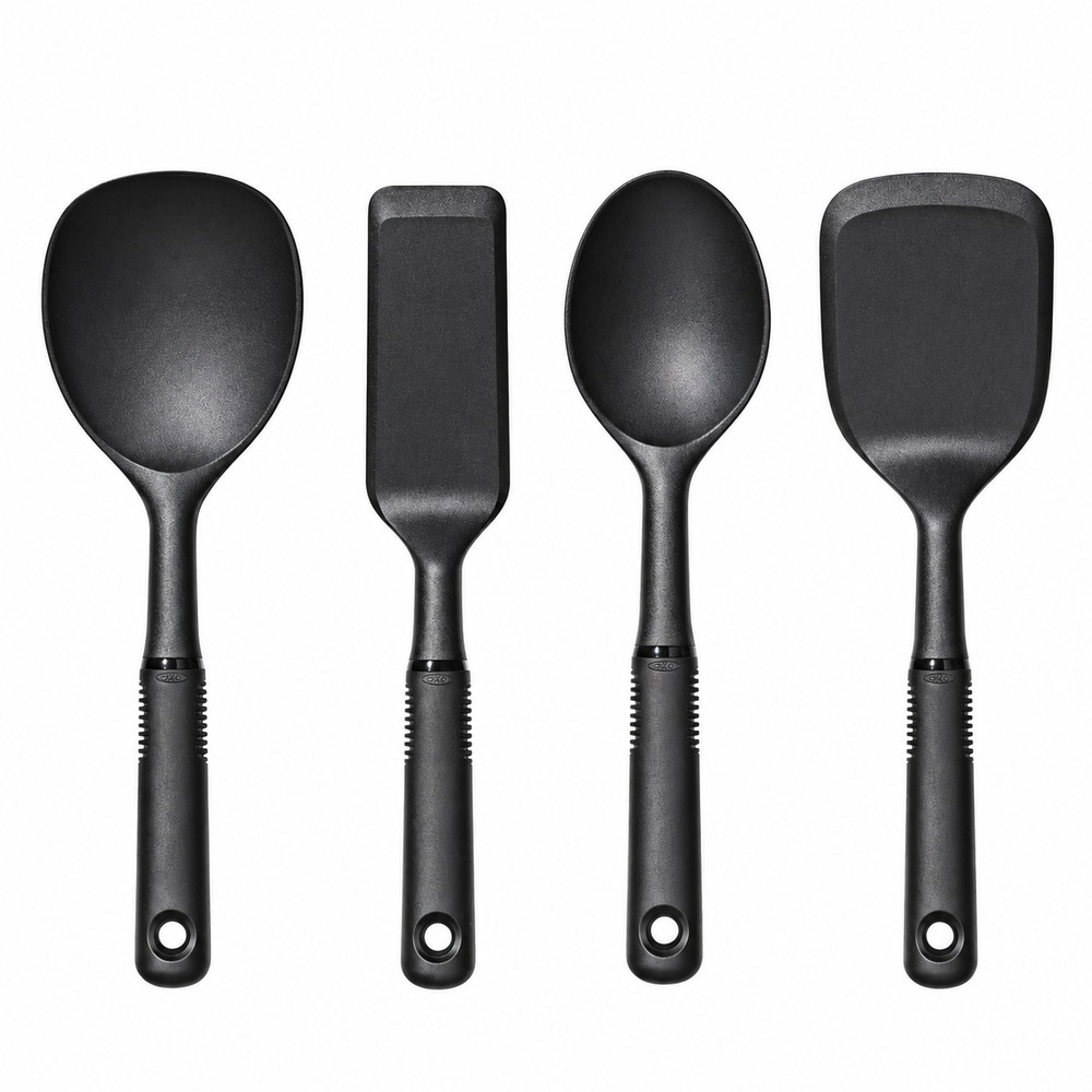 Four black silicone kitchen utensils with textured handles, including a ladle, spatula, spoon, and turner, arranged side-by-side on a white background.