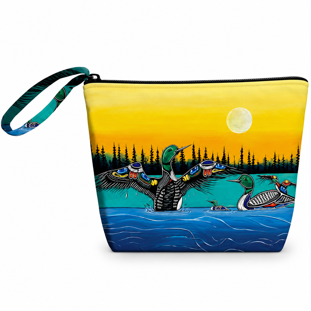 A zippered pouch with a wrist strap, featuring a colorful printed design of loons in a lake at sunset. The pouch has a yellow-to-orange sky, blue water, pine trees, and two loons, with a black zipper and black trim.