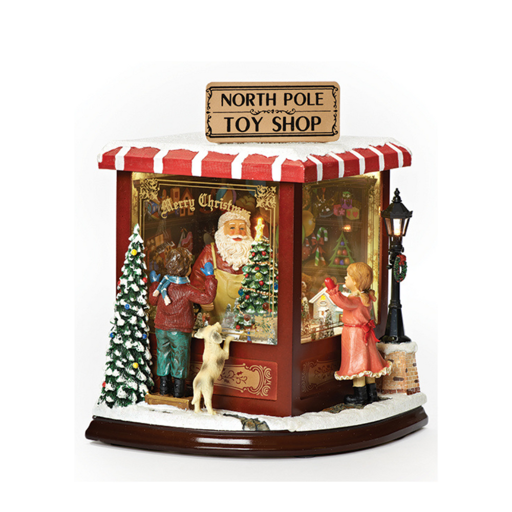 Christmas-themed toy shop display with Santa Claus, reindeer, and a girl in front of a store with 'North Pole Toy Shop' sign.
