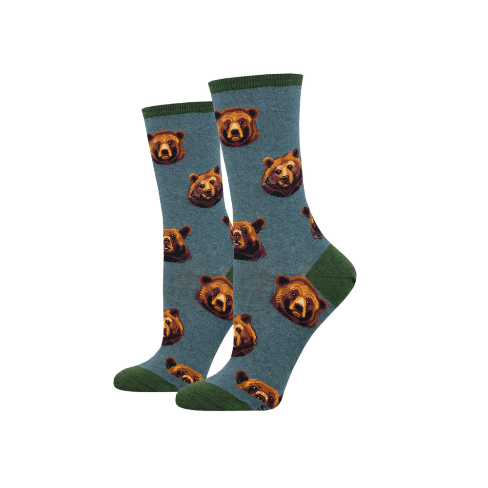 A pair of teal heather socks with a pattern of bear faces, worn by a person.