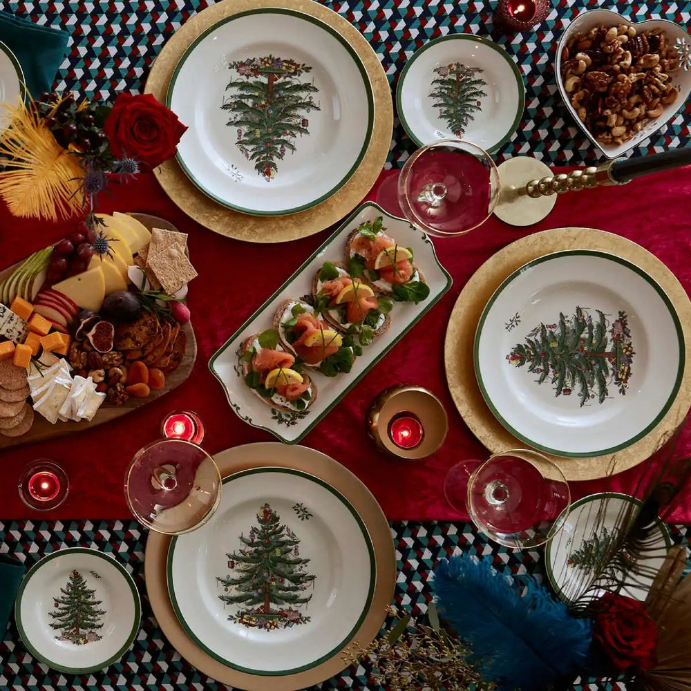 Decorative Christmas table setting with plates, candles, and food.
