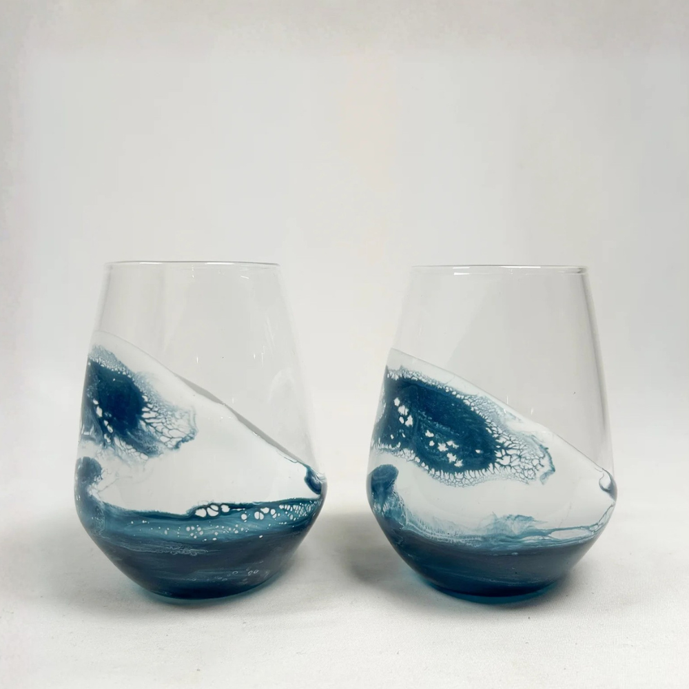 Stemless wine glass set in Navy White Metallic design by Lynn & Liana, featuring elegant swirls of deep blue, white, and metallic accents.