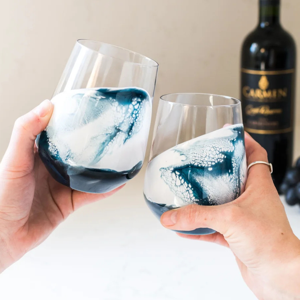 Stemless wine glass set in Navy White Metallic design by Lynn & Liana, featuring elegant swirls of deep blue, white, and metallic accents.
