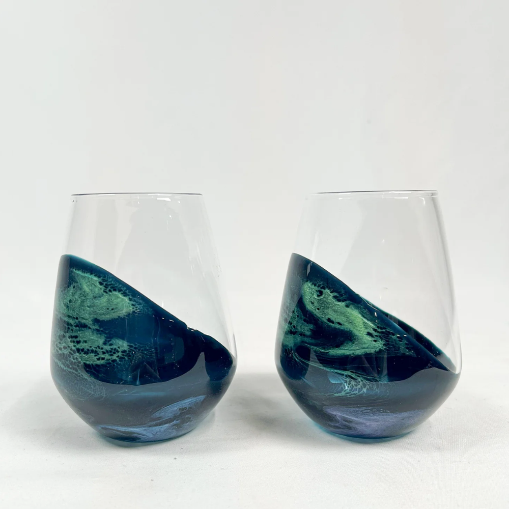 Stemless wine glass set in Northern Lights design by Lynn & Liana, featuring vibrant swirls of blue, green, and purple resin art.