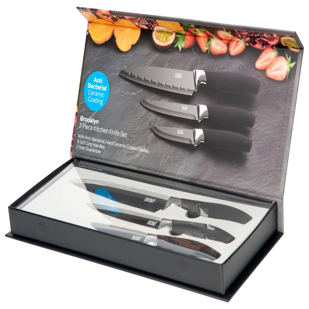 Set of knives in a Brooklyn branded knife set packaging with a decorative background of fruits and vegetables.