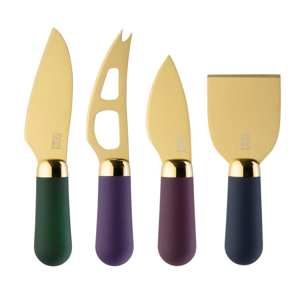 Set of four cheese knives with gold blades and dark handles on a white background