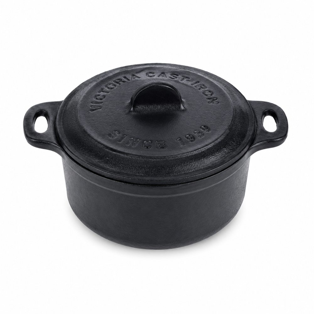 Black cast iron pot with lid on a white background