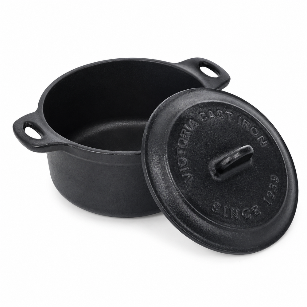 Black cast iron pot with lid on a white background