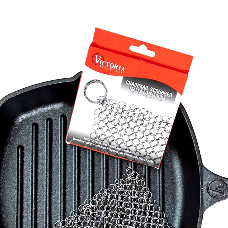 Victoria brand chainmail scrubber with packaging over a cast iron skillet.