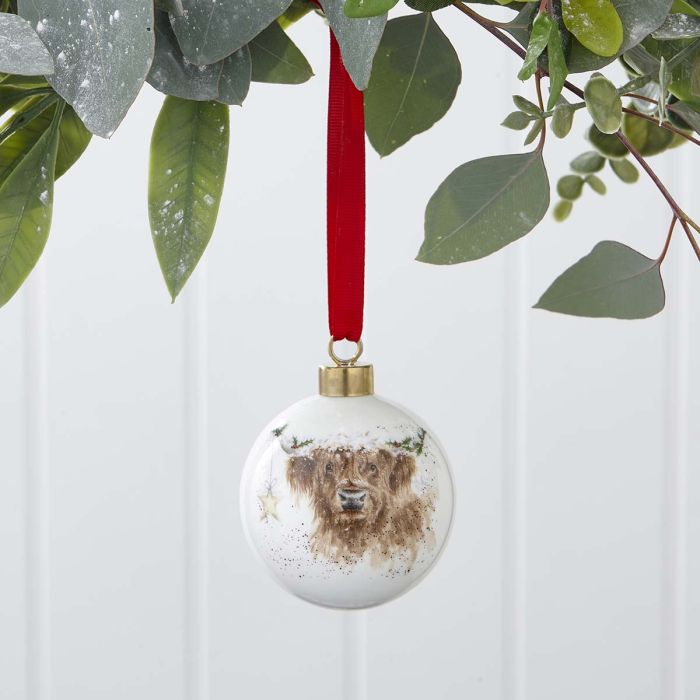 Christmas ornament with a highland cows face on a white background