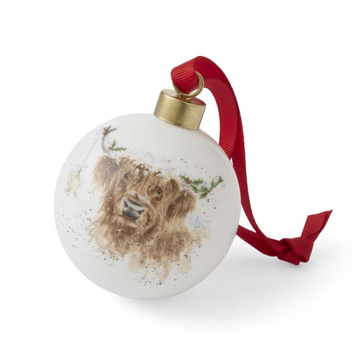 Round white ornament with a brown highland cow illustration and red ribbon on a white background