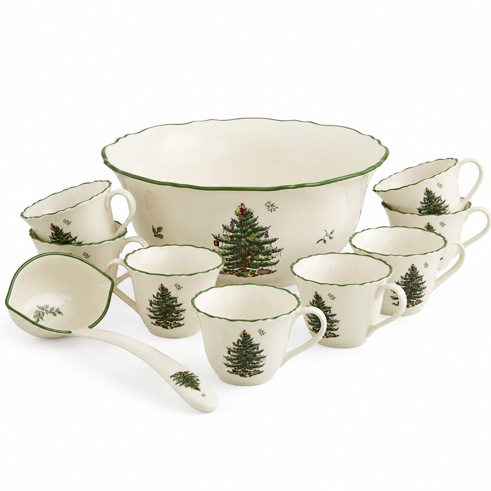A holiday-themed ceramic dinnerware set on a white background, featuring a large serving bowl, a mixing bowl, a ladle, and multiple cups and saucers decorated with green pine tree illustrations and green trim.