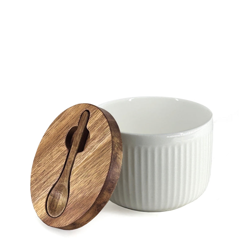 White ceramic bowl with wooden lid featuring a spoon cutout on a white background