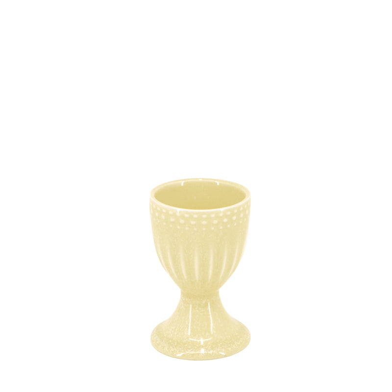 A yellow egg cup made of reactive glazed stoneware with a textured finish.