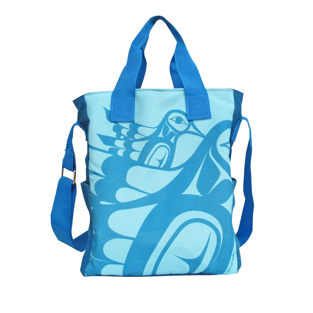 A blue shoulder bag featuring a geometric hummingbird pattern, with a cotton body and polyester straps.