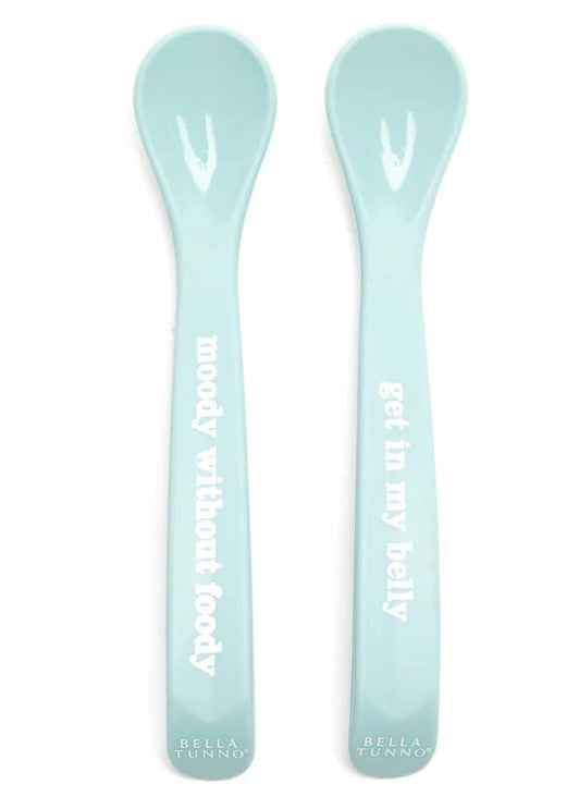 Two baby blue silicone spoons with text on the handle.
